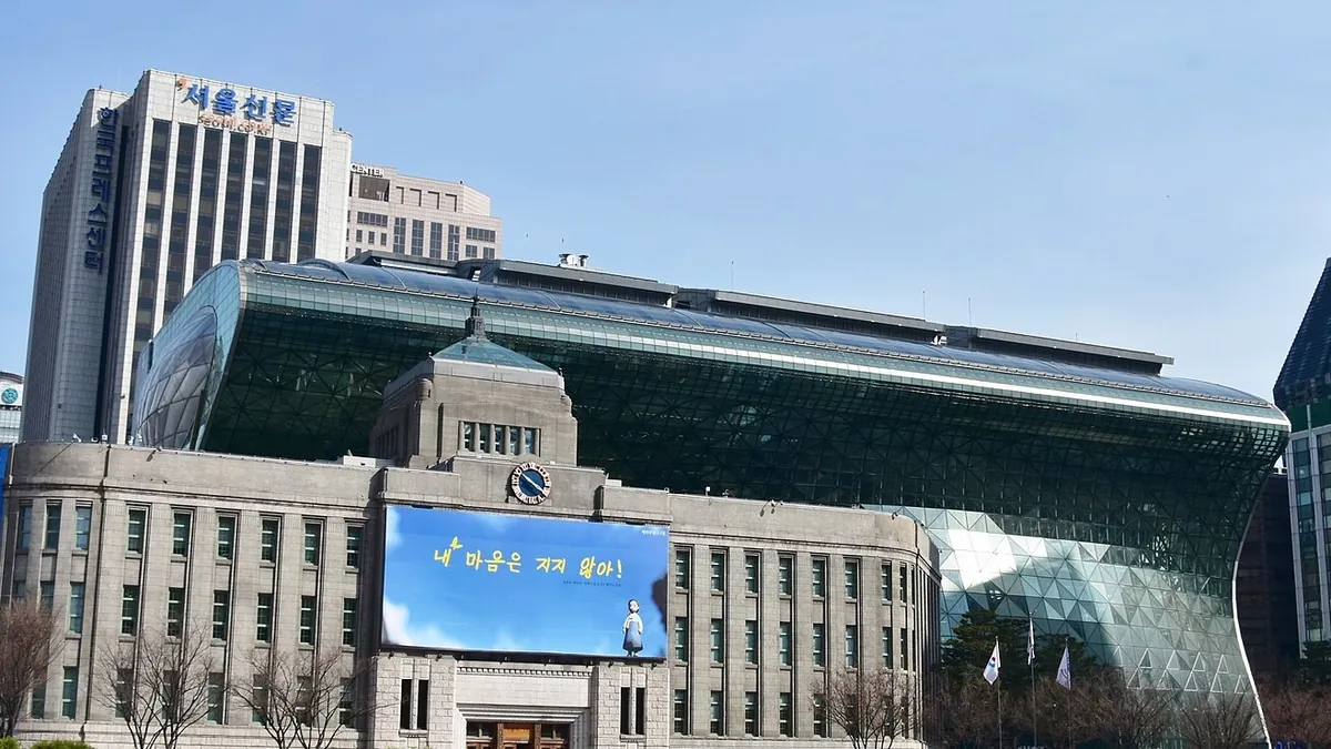 Seoul City Hall, the glass building over the older stone hall. Photograph by Richard Mortel, CC BY 2.0.