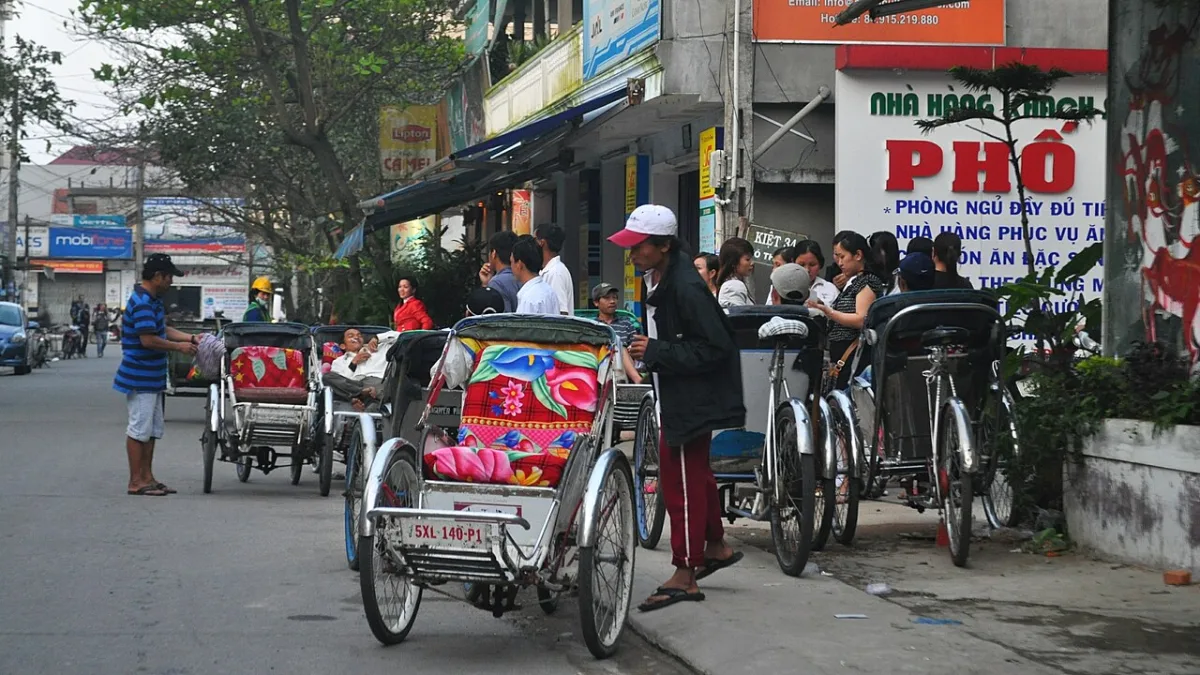 Cycle rickshaws for hire lined up beside a street in Hue, Vietnam Cycle rickshaws for hire lined up beside a street in Hue, Vietnam