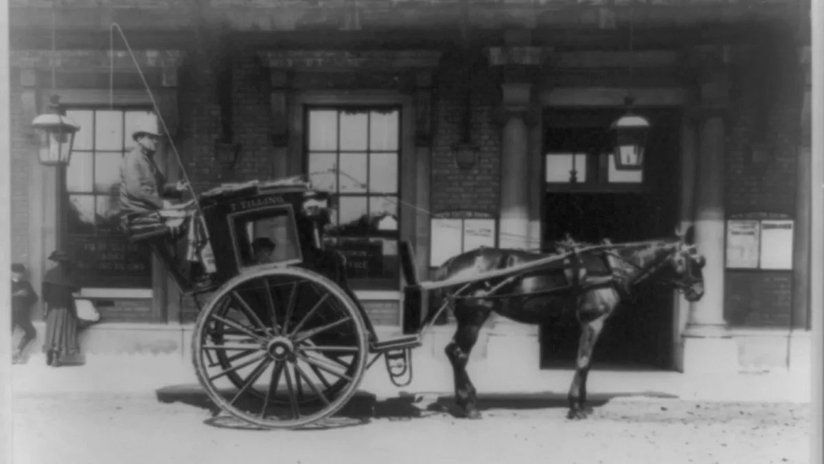 Horse-drawn T. Tilling hansom cab outside a London railway station, late 19th century